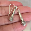 Aretes plateado con diseño de microfonos y guitarra
