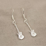 Aretes plateado con diseño de microfonos y guitarra